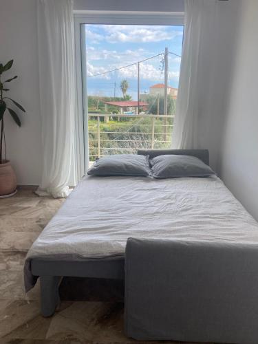 a bed in a room with a large window at Villa Delfini in Chrani