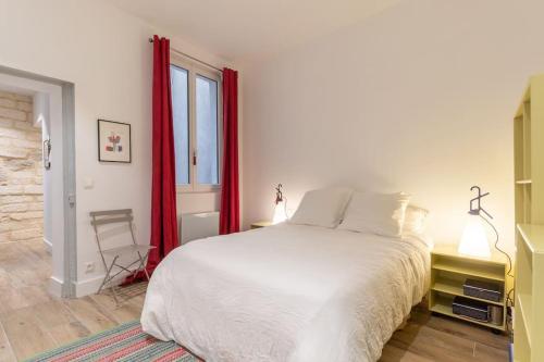 - une chambre avec un lit blanc et des rideaux rouges dans l'établissement L'Épicurien, Beau T2, Centre Historique, à Montpellier