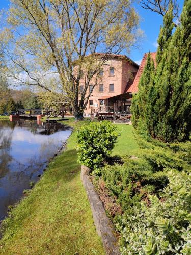 a house next to a river with a building at Dom dla dwojga w Starym Młynie w Brzeźnicy in Brzeźnica