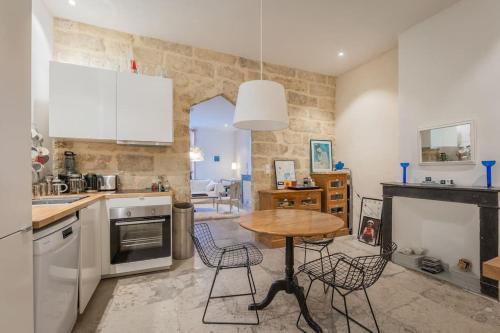 une cuisine avec une table et des chaises dans une pièce dans l'établissement L'Épicurien, Beau T2, Centre Historique, à Montpellier
