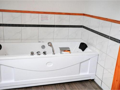 bañera blanca con grifo en el baño en Holiday home Scharzwald en Hinterfalkau
