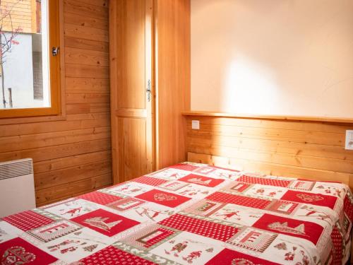 a bedroom with a bed with a red and white quilt at Appartement Uvernet-Fours, 3 pièces, 8 personnes - FR-1-504-7 in Uvernet