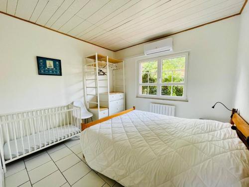 une chambre avec un grand lit et une fenêtre dans l'établissement Maison Basque avec Terrasse, Clim, et Wi-Fi à 600m de la Plage - Arcachon - FR-1-433-69, à Arcachon