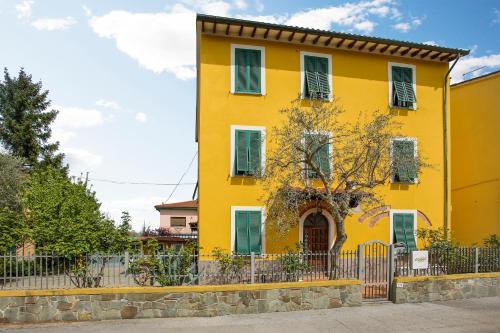 a yellow house with a fence in front of it at il Cantuccio in Lucca