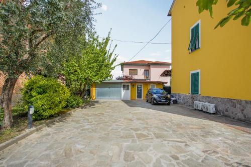a yellow house with a car parked in a driveway at il Cantuccio in Lucca