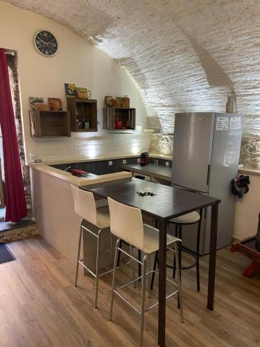 une cuisine avec une table, des chaises et un réfrigérateur dans l'établissement Wifi atypique Appartement Vieux Banyuls sur Mer, à Banyuls-sur-Mer