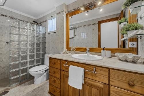 a bathroom with a sink and a toilet and a mirror at Famara Power Apartment in Famara
