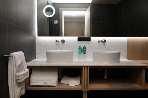 a bathroom with two sinks and a large mirror at Pico Terramar & SPA in Areia Larga
