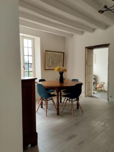 une salle à manger avec une table et des chaises en bois dans l'établissement la JoLie ruche, à Saint-Georges-sur-Cher