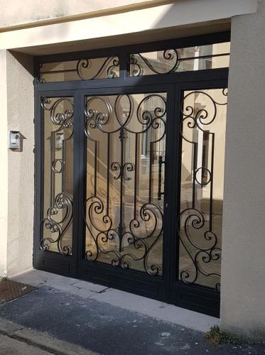 une porte avec une porte en fer forgé sur un bâtiment dans l'établissement The Victory, à Bayeux