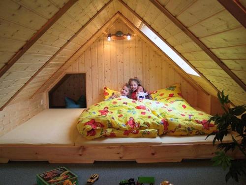 in the Oertel holiday home : فتاة صغيرة مستلقية على سرير في منزل شجرة