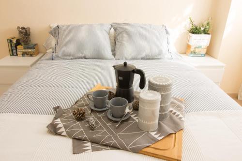 ein Tablett mit einem Wasserkocher und Tassen auf einem Bett in der Unterkunft Barlovento in Algarrobo