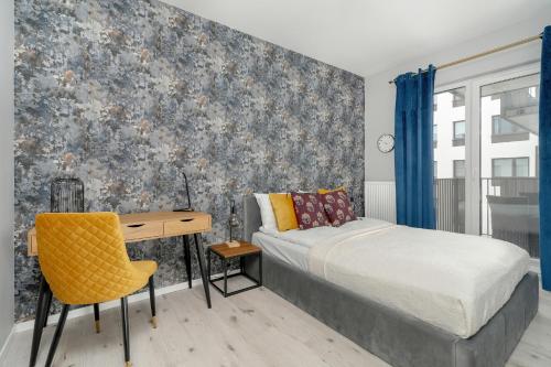 a bedroom with a bed and a desk at Beautiful Apartment with Balcony & Free Garage by Renters in Poznań