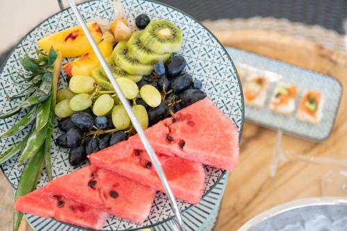 a plate of food with fruit on a table at Amaronda Resort & Spa Eretria in Eretria