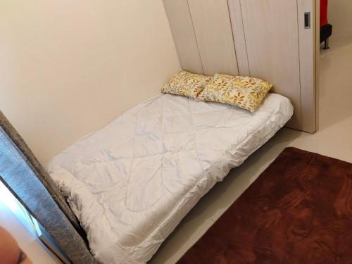マニラにあるStaycation in Quezon Cityの枕付きの部屋のベッド1台