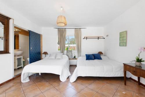two beds in a room with white walls at Villa Golf del Sur in San Miguel de Abona