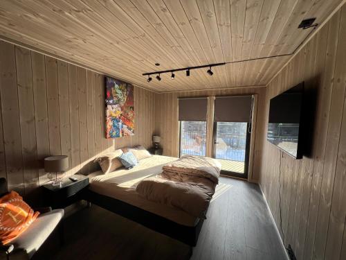 ein Schlafzimmer mit einem großen Bett in einem Zimmer mit Holzwänden in der Unterkunft Fjellandsbyen 307 in Hemsedal