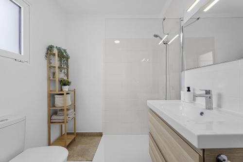 a white bathroom with a sink and a toilet at Gara Apt Puerto del Carmen in Tías