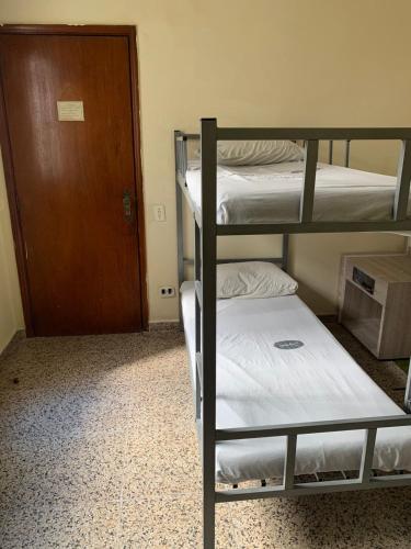 a room with two bunk beds and a door at Hotel Village in Sao Paulo