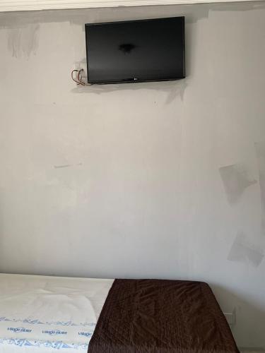a flat screen tv on a wall above a bed at Hotel Village in Sao Paulo