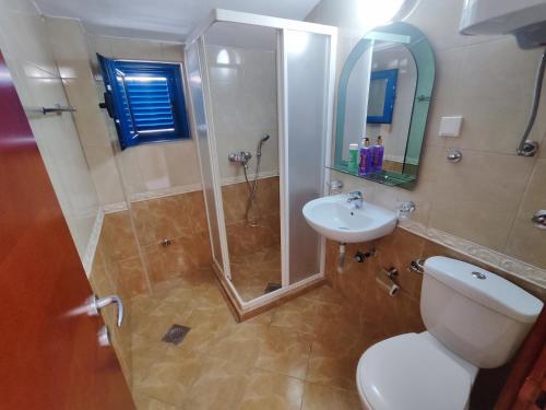 a bathroom with a shower and a toilet and a sink at Glory Suites in Budva