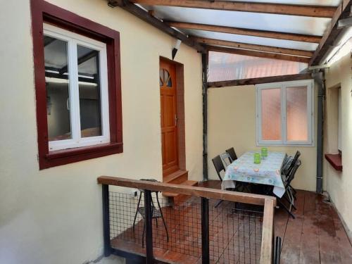 a patio with a table and chairs on a balcony at LE CHANT DE LA RIVIERE in Sainte-Marie-aux-Mines