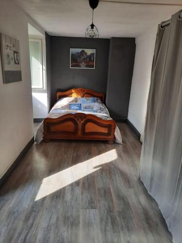 une chambre avec un lit dans le coin d'une pièce dans l'établissement LE CHANT DE LA RIVIERE, à Sainte-Marie-aux-Mines