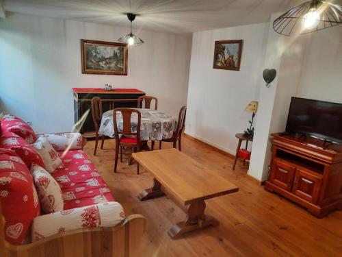 a living room with a couch and a table and a piano at LE CHANT DE LA RIVIERE in Sainte-Marie-aux-Mines