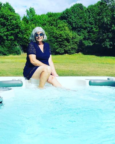 une femme assise au bord d'une piscine dans l'établissement Domaine de Tapies 2 gites jusqu à 19 personnes, à Cornus