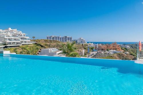 een uitzicht op de oceaan vanuit het overloopzwembad van een resort bij Newly Built Top Modern 3 BDRM Townhouse with Sea View in Estepona