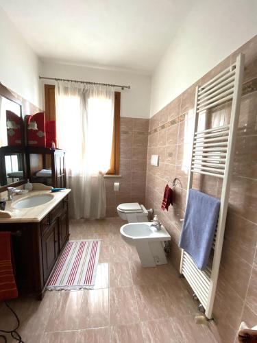 a bathroom with two sinks and a toilet and a sink at Giulietta Home in Belfiore