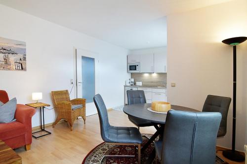 ein Wohnzimmer mit einem Tisch und Stühlen sowie eine Küche in der Unterkunft Miramar App. 15 in Ahlbeck