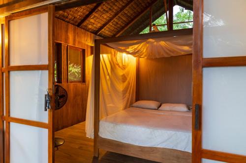a bedroom with a canopy bed in a room at Jardín Botánico del Pacífico y Mecana Ecohotel in Bahía Solano