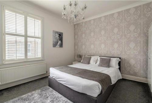 - une chambre avec un grand lit et un lustre dans l'établissement Entire 2-bedroom house with garden, à York