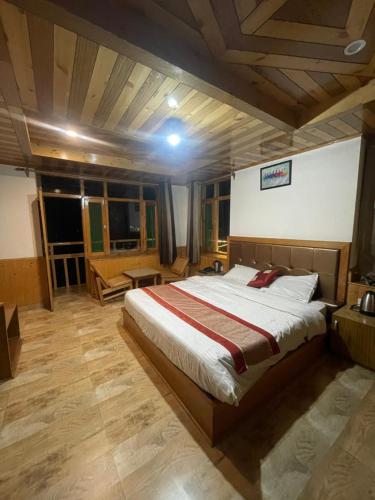 a bedroom with a large bed in a room with wooden ceilings at heavens retreat manali in Manāli