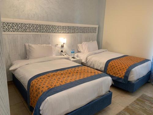 - 2 lits dans une chambre d'hôtel avec des toilettes dans l'établissement ايليت, au Caire