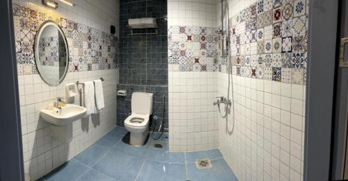 La salle de bains est pourvue de toilettes et d'un lavabo. dans l'établissement ايليت, au Caire