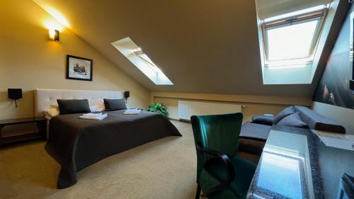 a bedroom with a bed and a couch and a window at Villa Regia in Košice