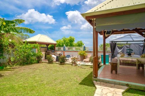 a patio with a table and a gazebo at Villa Sun and Sea in Deshaies