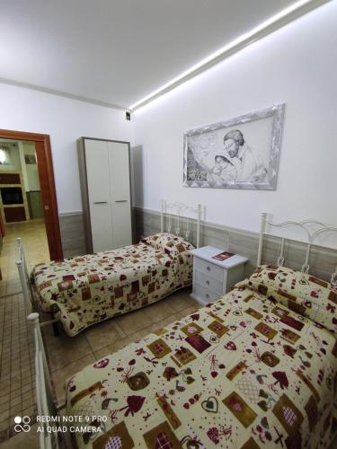 a bedroom with two beds and a picture on the wall at Re Sole Resort&Spa in Grottaglie
