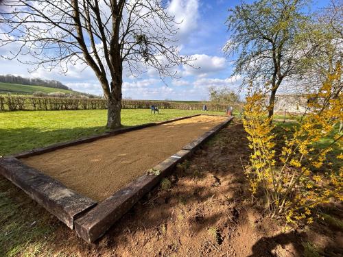 a garden with a dirt road and a tree at Aux 2 cerisiers in Virton