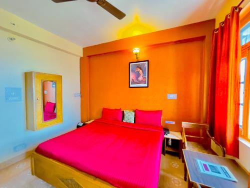 1 dormitorio con 1 cama grande con sábanas rojas en Grand view lodge and Restaurant Dharamshala en Dharamshala