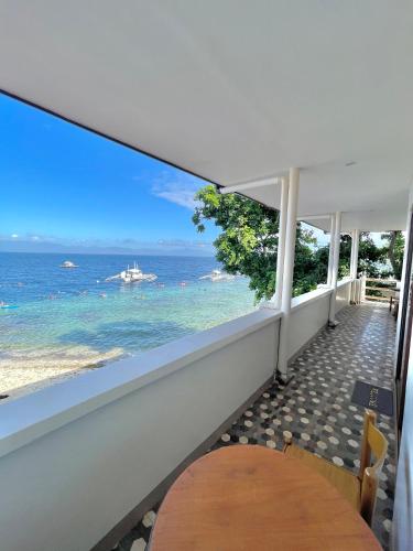a balcony with a table and a view of the ocean at Marina Village in Moalboal