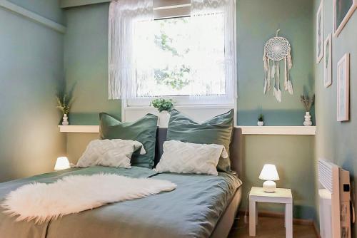ein Schlafzimmer mit einem Bett mit Kissen und einem Fenster in der Unterkunft CityCharme-Apartment in Braunschweig