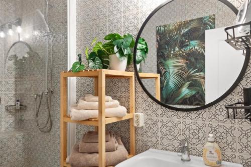 ein Badezimmer mit einem Regal mit Handtüchern und einem Spiegel in der Unterkunft CityCharme-Apartment in Braunschweig