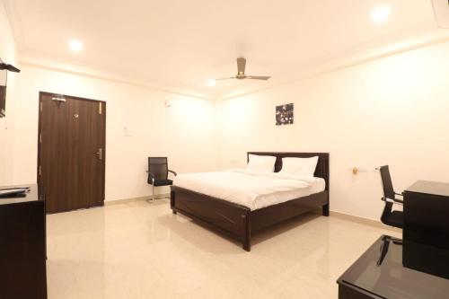 een slaapkamer met een bed en een televisie. bij MN Stays in Vijayawāda