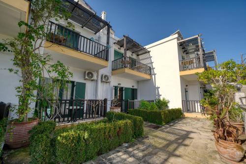 Une rangée de maisons avec balcon et plantes dans l'établissement Erodios Apartments, à Kalyves