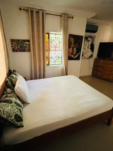 a bedroom with a large white bed with a window at Heda House in Sanyang