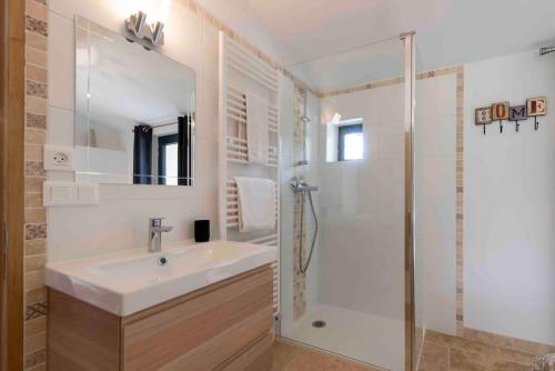 une salle de bain blanche avec un lavabo et une douche dans l'établissement MAS SAINTE CROIX 4 étoiles - PRESTIGE - PISCINE CHAUFFÉE - VAISON - MONT VENTOUX - PROVENCE, à Vaison-la-Romaine