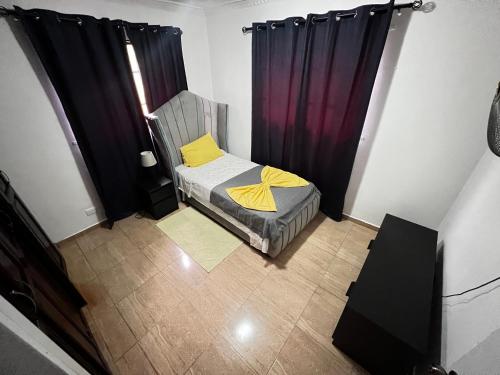 a small bedroom with a bed and curtains at Casa Deisy in Santiago de los Caballeros